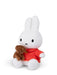 A white stuffed bunny toy wearing a red shirt and holding a brown stuffed dog toy.