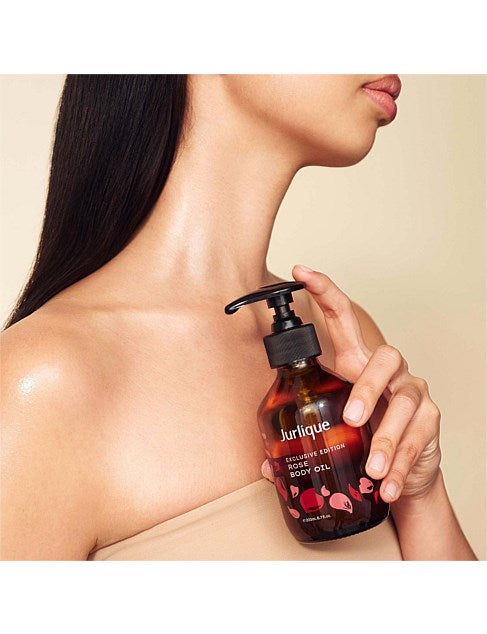 A woman holding a bottle of Jurlique body oil.