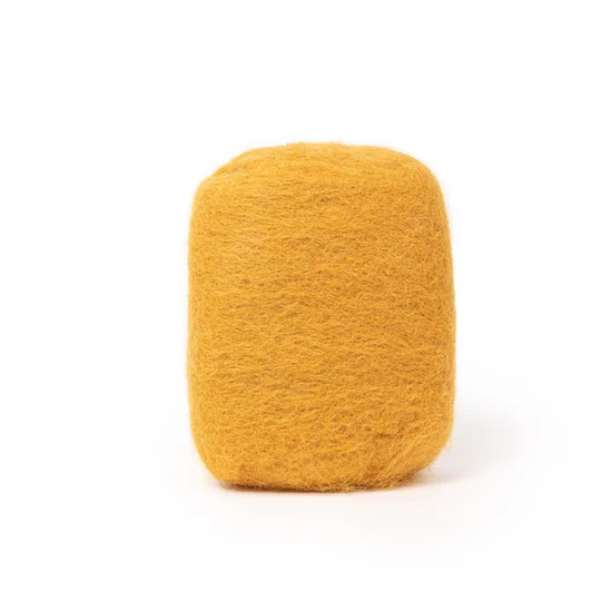 A single, cylindrical object made of a fuzzy, yellow material, possibly a type of wool or cotton, is shown against a white background.