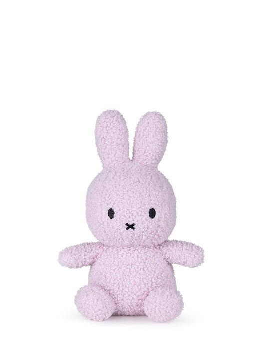 A small, pink stuffed bunny toy is sitting on a white background.