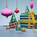 a festive arrangement of Christmas-themed items, including ornaments, candles, and gift boxes, all set against a blue background.