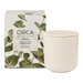 a white ceramic candle in a box with a green leaf design, and a white ceramic jar next to it.