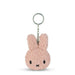 A pink, fluffy keychain in the shape of a bunny with a black nose and eyes.