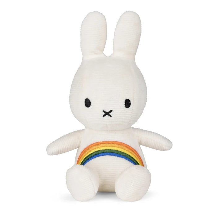 A white plush toy rabbit with a rainbow patch on its belly.
