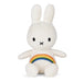 A white plush toy rabbit with a rainbow patch on its belly.