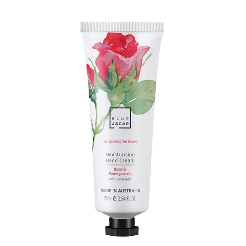 A tube of hand cream with a rose and pomegranate design.