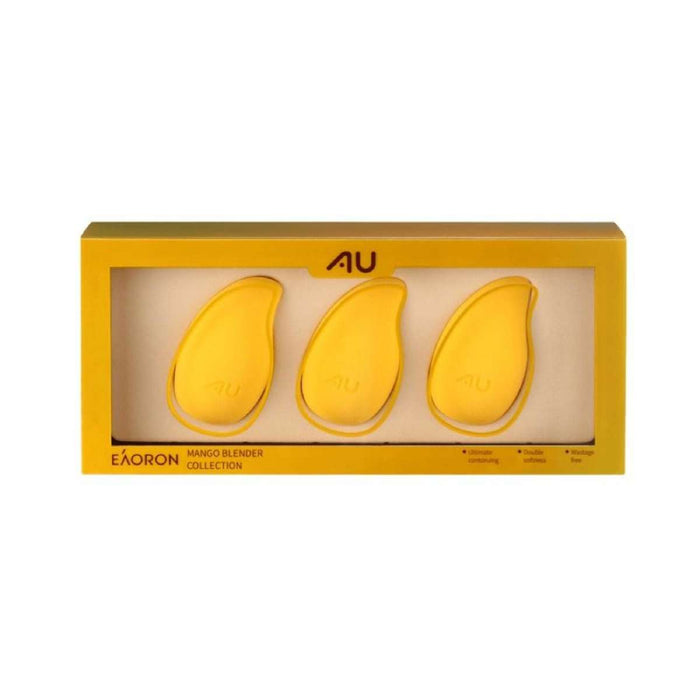 a set of three yellow mango-shaped makeup blenders arranged in a yellow box with a gold border.