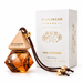 a Blue Jacar Home Mini Diffuser, a small orange-colored diffuser with a wooden top and a gold-colored metal string. The diffuser is placed next to its packaging box, which is white and has gold text and graphics on it.