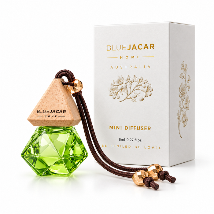 a BLUEJACAR Home Australia Mini Diffuser, a green glass bottle with a wooden top, and its accompanying white box.