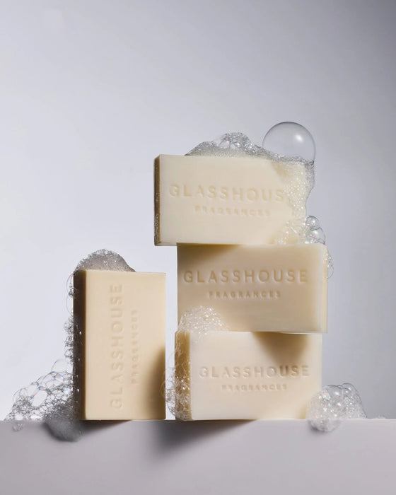 three rectangular bars of soap with the word "GLASSHOUSE" printed on them, with bubbles surrounding the bars.