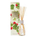 a glass vase with a clear glass body and a silver cap, filled with reed sticks, and a box with a green and white floral design and red berries printed on it.