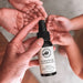 A hand holding a bottle of hand sanitizer spray.