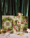 a Christmas-themed advent calendar with a wreath design, candles, and other holiday decorations arranged on a table.