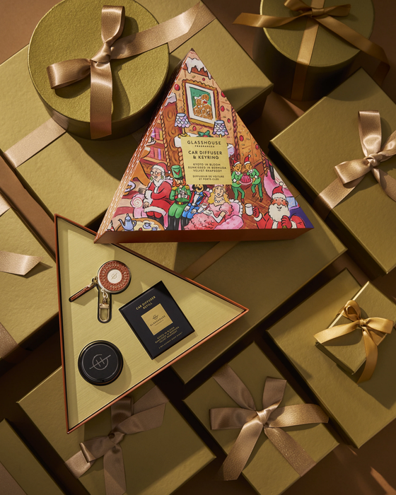 a collection of gift boxes and presents, some of which are wrapped in gold ribbons. The boxes appear to be gift-wrapped and contain various items, such as a small black box and a larger box with a colorful, illustrated design. The overall scene suggests a festive or holiday-themed setting, with the gift boxes and presents arranged in a visually appealing manner.