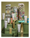 a collection of various skincare and beauty products, including tubes, jars, and bottles, arranged on a green surface. The products appear to be part of a gift set or a display, with some of them placed on top of green boxes. The image does not contain any text, and the focus is on the visual presentation of the products.