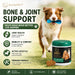 The image is an advertisement for a pet food product called "Auipet Bone & Joint Support". It features a dog holding a blue toy in its mouth, with a green jar of the product placed next to it. The ad highlights the product's benefits for dogs, such as joint health support, mobility, and comfort, as well as promoting an active lifestyle and a premium formula. The ad also emphasizes the product's natural ingredients and veterinary-formulated formula, making it safe and gentle for daily use.