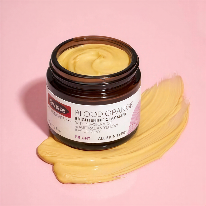 A jar of Swiss Elegant Beauty Blood Orange Brightening Clay Mask with Niaciname and Australian Yellow Racin Clay is shown against a pink background.