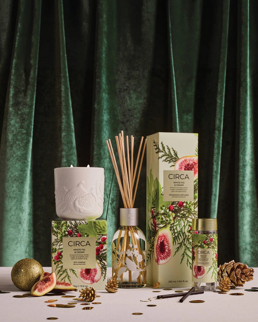 a collection of products from the brand 'CIRCA', including a candle, diffuser, and other items, all set against a green velvet background.