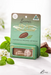 a product called "My lips are sealed" by Lucamar, a natural and organic lip balm. The product is displayed in a green box with a picture of a chocolate bar and mint leaves. The background includes a blurred white background with some flowers.