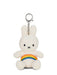 A white plush bunny toy with a rainbow-colored band around its belly.