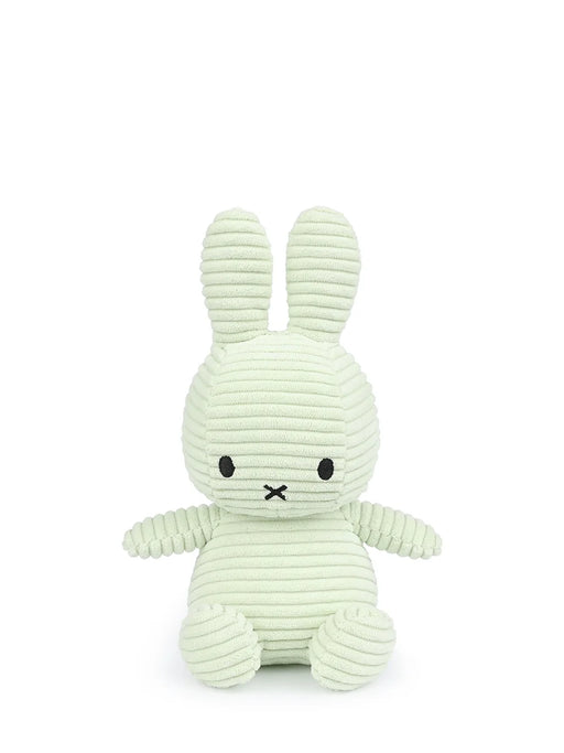 A light green plush bunny toy with black eyes and mouth.