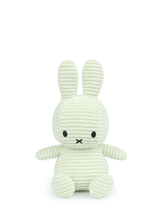 A light green plush bunny toy with black eyes and mouth.