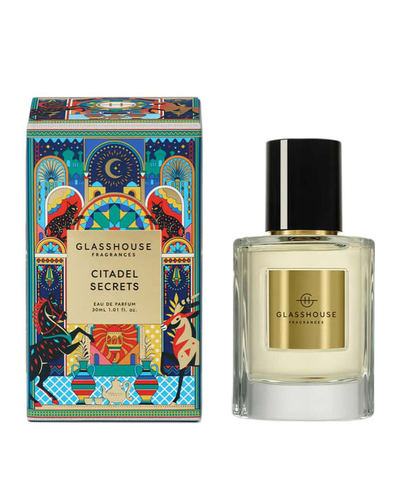 a perfume bottle and its packaging. The perfume bottle is a clear glass bottle with a black cap, and the packaging is a colorful box with a gold and black design.