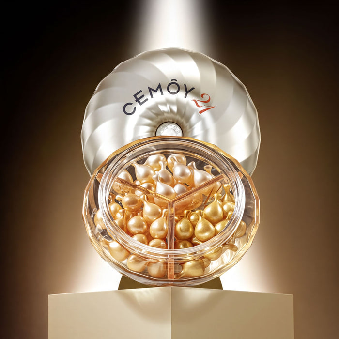a large, round, white container filled with golden-colored capsules, placed on a pedestal.