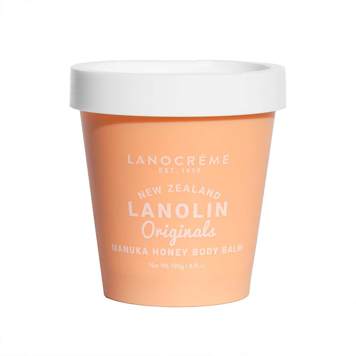 A container of Lanolin Origins Manuka Honey Body Balm, with a white lid and a peach-colored exterior.