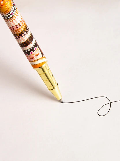 A gold-colored pen is drawing a line on a white surface.