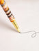 A gold-colored pen is drawing a line on a white surface.