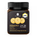 a bottle of Manuka Honey with a black cap and a label that includes text and images.