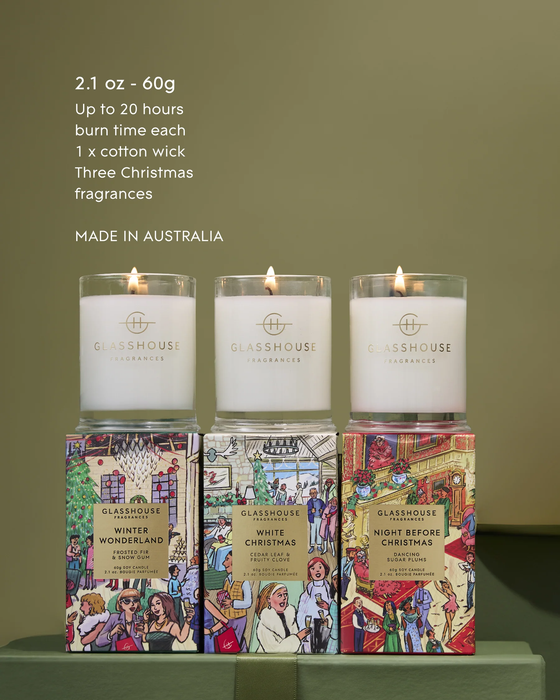 Three candles from the brand Glasshouse, each with different scents, are displayed on a table.