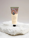 A tube of "Koh" Native Frangipani hand cream with macadamia seed oil is displayed on a white rock.