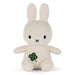A white stuffed bunny toy with a green clover design on its chest.