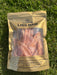 A package of raw meat, specifically chicken maw, laid on the grass.