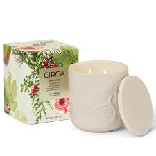 A white ceramic candle with a floral design and a matching lid, placed next to its packaging box.