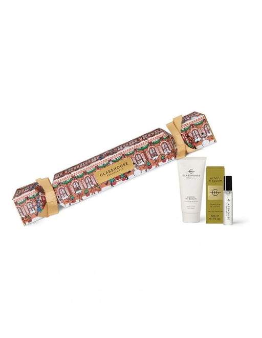 A gift set containing a perfume, a cream, and a box of lotion, all wrapped in a decorative box with a Christmas-themed design.