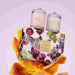 two glass jars with candles, placed on top of a floral box with a vibrant design.