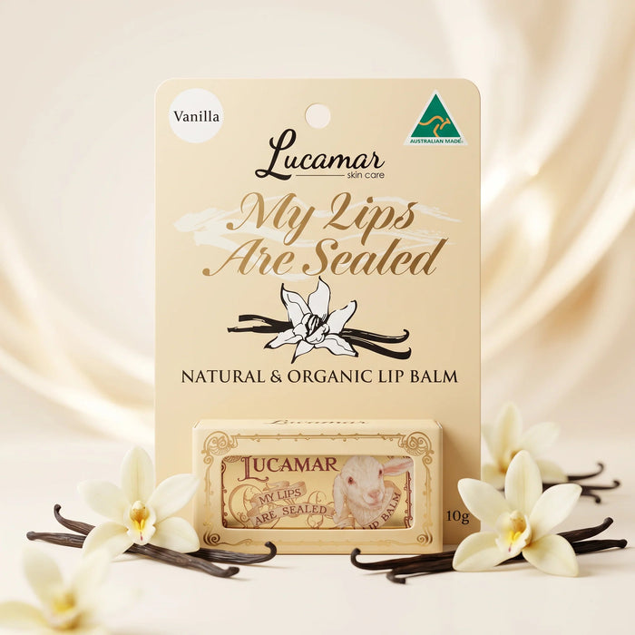 a package of Lucamar lip balm, with a small box of the lip balm placed next to it. The packaging is adorned with white flowers, and the background is a light beige color.