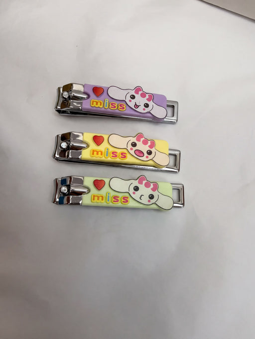 Three colorful nail clippers with cartoon faces and the word "miss" printed on them.