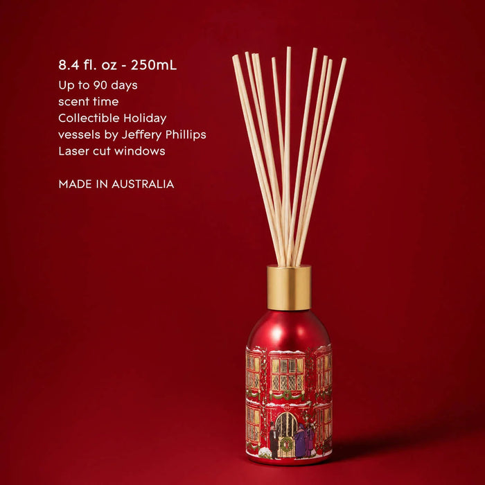 A red diffuser with a gold-colored base, filled with white sticks, against a red background.