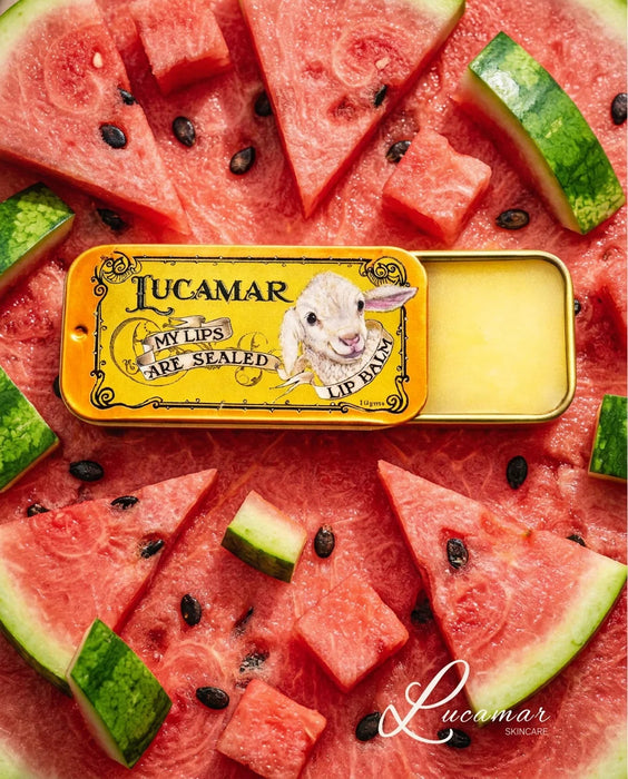 a tin of Lucamar lip balm surrounded by slices of watermelon and black seeds.