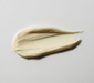 A small amount of cream is spread across a white surface.