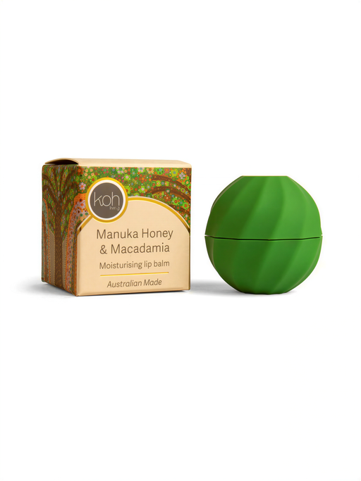 a box of Manuka Honey & Macadamia lip balm next to a green, round container of the same product.