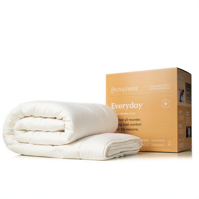 a white comforter or duvet placed on top of a cardboard box labeled "Everyday" and "LIMESTONE COAST SOUTHAUSTRALIA".