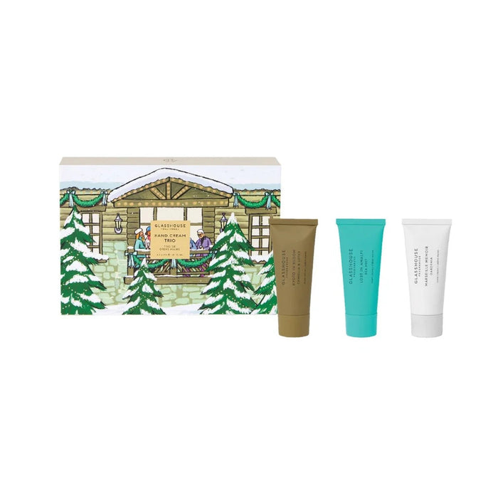 A set of three tubes of skincare products, each with a different color, placed next to a box depicting a winter scene with a cabin and trees.