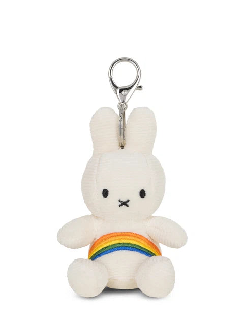A white plush bunny toy with a rainbow-colored band around its belly.
