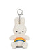 A white plush bunny toy with a rainbow-colored band around its belly.