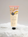 A tube of coconut and finger lime hand cream is shown against a white background.